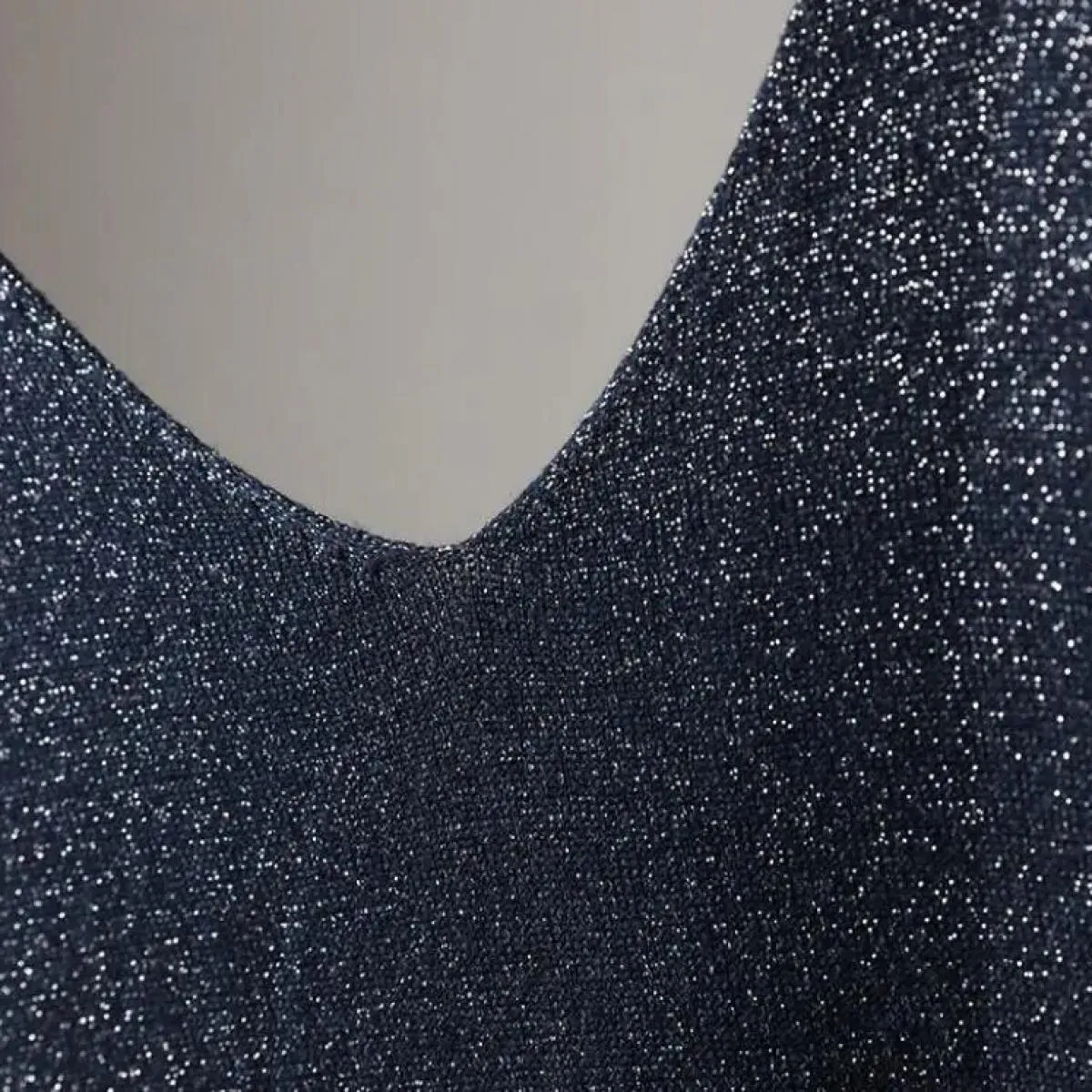 Gilet in maglia brillante da donna con scollo a V estivo alla caviglia che indossa una maglietta senza maniche